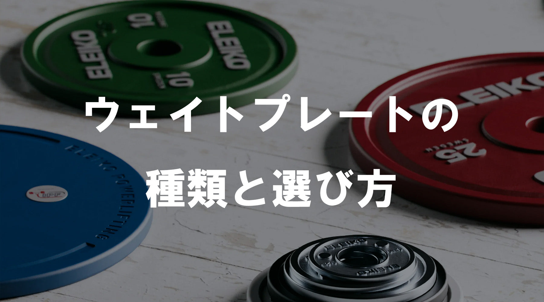 カラー別のウェイトプレートを俯瞰で配置した構図、赤・青・緑のプレートと金属ハブが見える静物シーンで種類と選び方を解説する導入ビジュアル