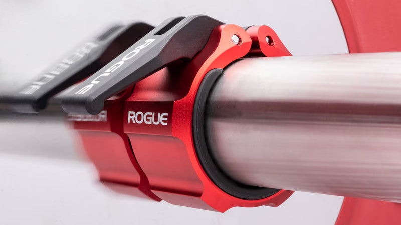 ROGUE USAアルミニウムカラー 2.0 レッドをバーベルスリーブに装着した状態を斜め横から拡大し、CNC加工アルミボディとラバーライニング構造が分かるディテール