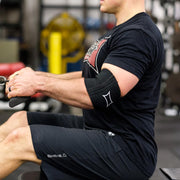 SLINGSHOT ビギー コンプレッションカフ ブラックを装着した腕でトレーニング中の側面視点。実使用時の可動域とフィット感を確認できる構成