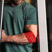 SLINGSHOT コンプレッションカフ2.0 レッドを着用した前腕と肘のアップ。筋肉の張りと縫製ラインが分かる角度で耐久性を表現した構成