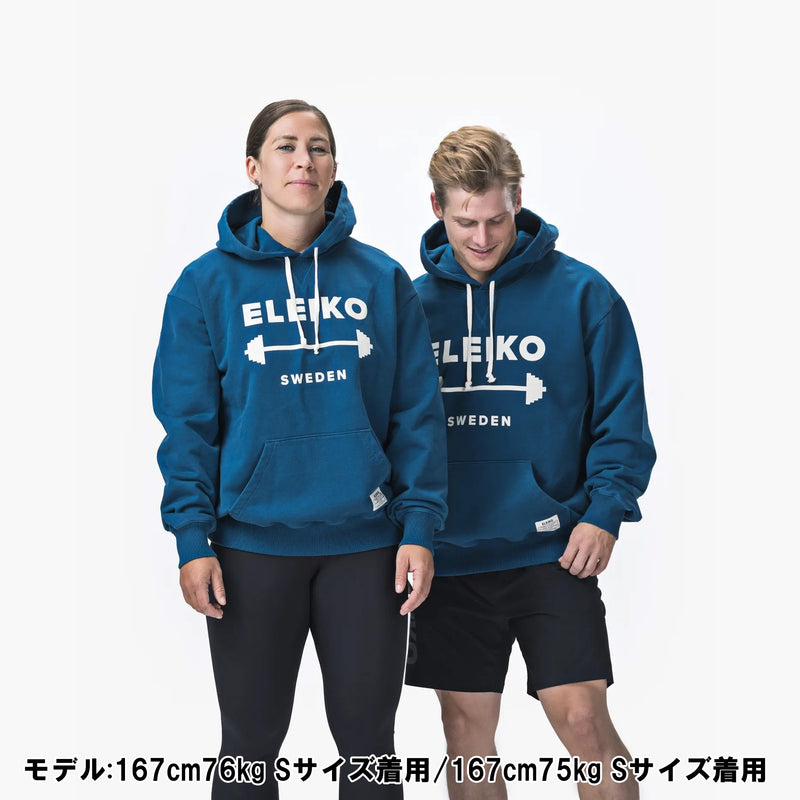 ELEIKO 1957パーカー ブルー 男女モデル正面着用比較構図、サイズ感と着丈バランス・ロゴ配置が分かるスタイリング例
