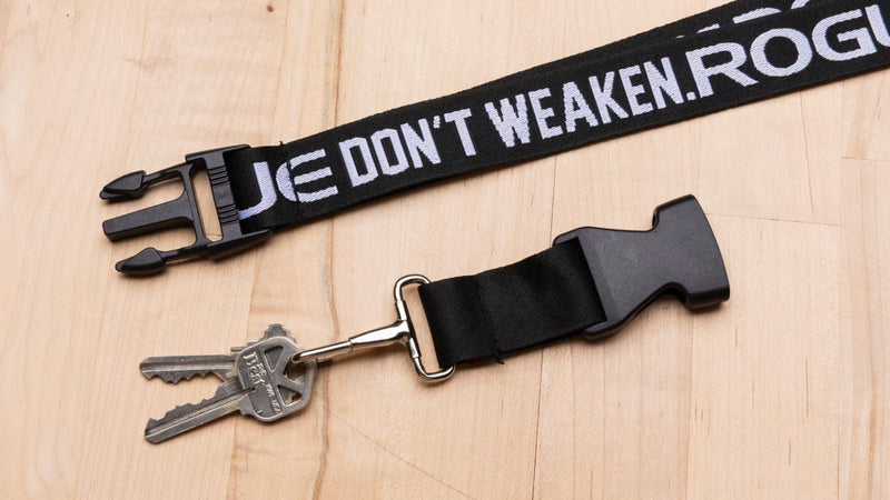 ROGUE ランヤード Don't Weaken ブラックのバックル分離状態を上方から捉えた構図。樹脂バックル、金属リング、キー装着部の接続構造が確認できるアパレルアクセサリー