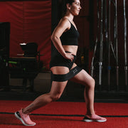 SLINGSHOT ヒップサークル ブラックを太ももに装着したランジ動作の横からの視点。ヒップバンド使用時の脚の角度と可動域が分かる構成