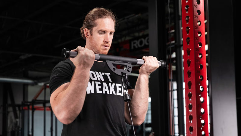 Mutant Metals ARC ケーブルアタッチメント ブラックでバイセップカールを行う様子、胸元付近で引き上げたポジションとバー中央形状が分かる構図