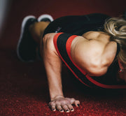 SLINGSHOT スリングショットプッシュアップ レッド＆ブラックを装着した側面寄り視点。床に近い角度から上腕と肩周りのフィット感と負荷分散が分かる構成。