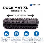 黒のROCK MAT XLを正面から見た構図で、通常サイズとの幅と奥行きの違いが想定しやすい横長設計と、全面に配置された突起パターンを確認できる大型モデルの外観