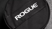 ROGUE エコーストロングマンサンドバッグ ブラック 両腕で抱え込み持ち上げる正面寄りのクローズアップ、力感と重量感が伝わる構図