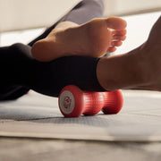 ROLL Recovery R3 フットローラー レッドをふくらはぎへ当てて使用する様子。下腿部をピンポイントでほぐすモビリティシーン