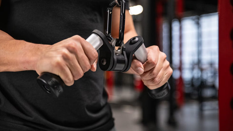 シルバーのROGUE Vグリップ ケーブルアタッチメントを使用し、トライセプスプッシュダウン中の手元を正面から捉えた回転式グリップの使用例