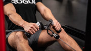 シルバーのROGUE Vグリップ ケーブルアタッチメントを使用し、シーテッドローで腕を伸ばした開始姿勢を正面から捉えた使用例