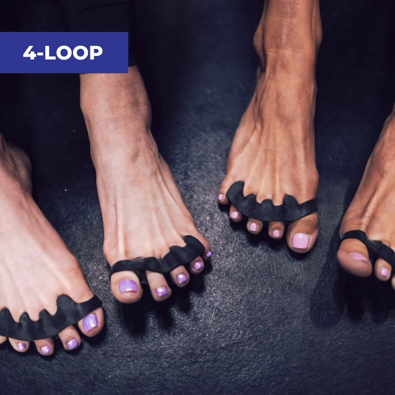 黒のThe Toe Spacerを両足に装着した状態を上から見下ろした構図で、4ループ構造によって足指が自然に開いた配置と接地時の安定感を確認できるモビリティ用フットケアツールの使用状態