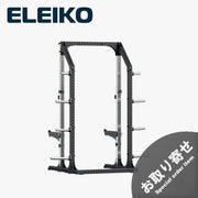 ELEIKO プレステララック ブラックとステンレスカラーを組み合わせたハーフラック。斜め前方から見た全体構造で、シルバーの後方支柱、ブラックのフロントフレーム、左右のセーフティアーム、プレート収納ホルダーを備えたフリーウェイトトレーニング用ラック。