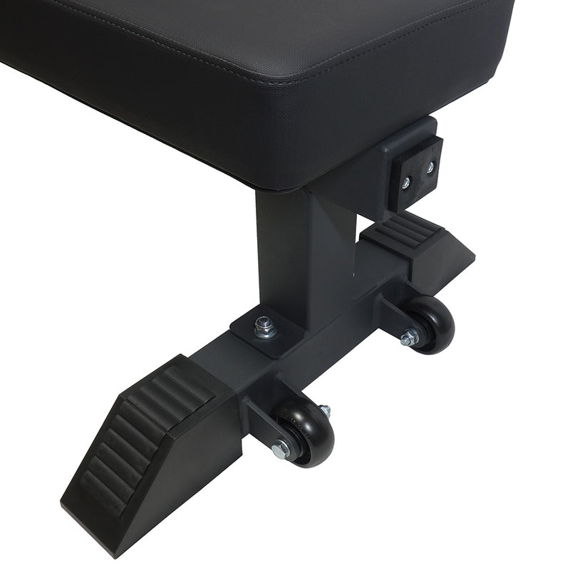 MBC コンペティションフラットベンチ ブラックを持ち上げて移動する様子を横方向から捉えた構図。グリップハンドル位置とキャスターの実用性が分かる使用シーン