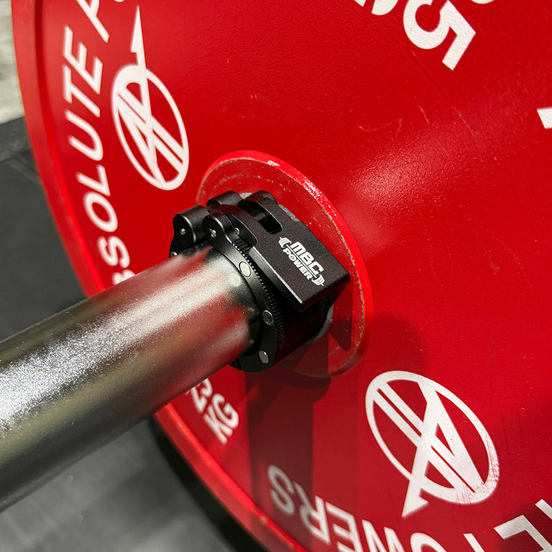 MBC アルミニウムカラー マグネット ブラックをバーベルスリーブに装着した状態を側面から捉えた構図。プレート固定時の装着位置とクランプレバーの操作性が分かる。